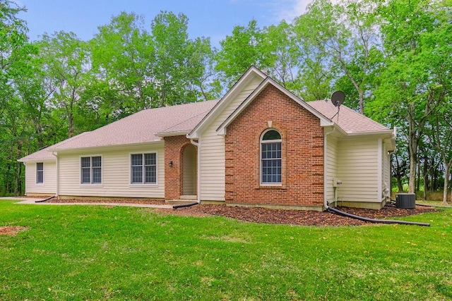 view of front of home with central AC and a front lawn