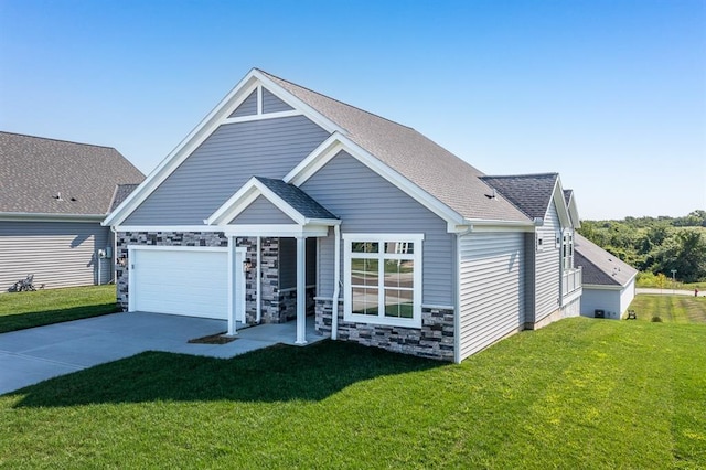 view of front of house with driveway, stone siding, a shingled roof, and a front yard