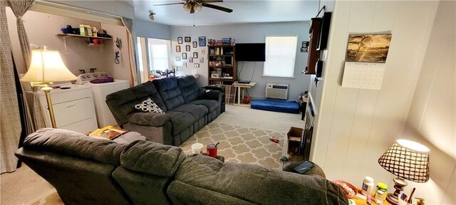 living room featuring ceiling fan, separate washer and dryer, light carpet, and a wall unit AC