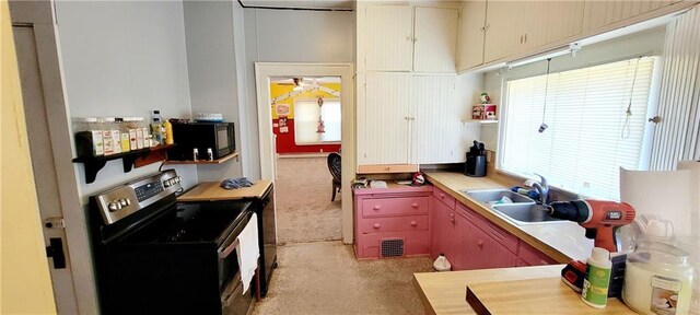 kitchen with a healthy amount of sunlight, ceiling fan, sink, and stainless steel range with electric stovetop