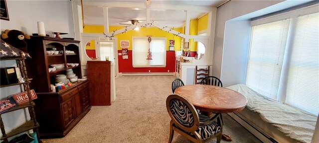 dining space with baseboard heating, light carpet, and ceiling fan