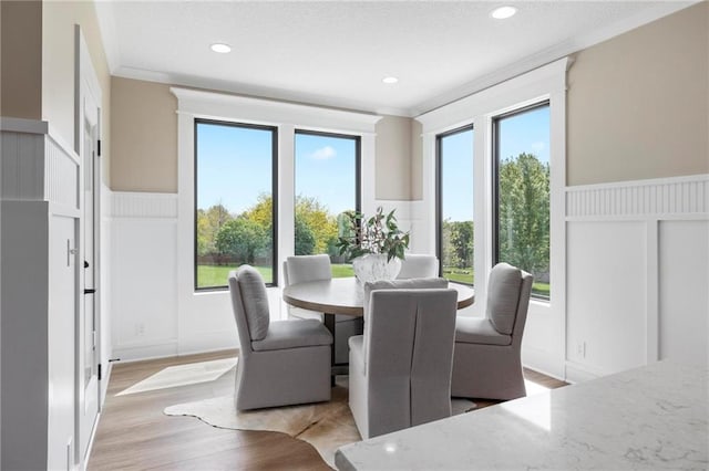 dining area featuring crown molding, plenty of natural light, and light hardwood / wood-style flooring