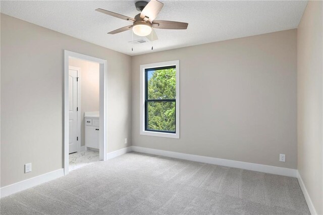 carpeted empty room with a textured ceiling and ceiling fan