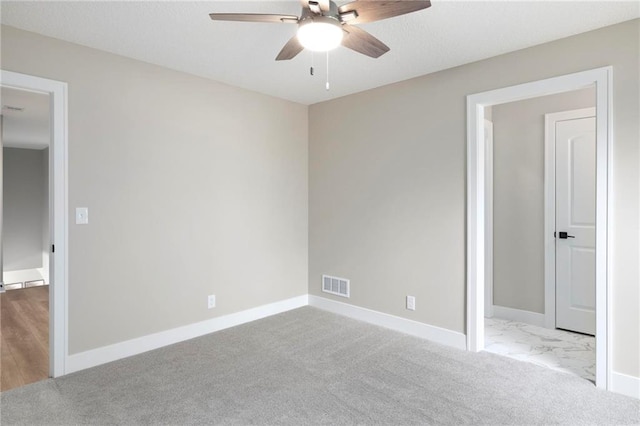 carpeted spare room featuring ceiling fan