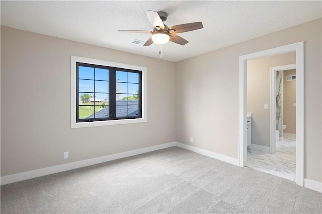 carpeted spare room with a textured ceiling and ceiling fan