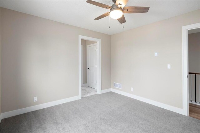 empty room with light colored carpet and ceiling fan