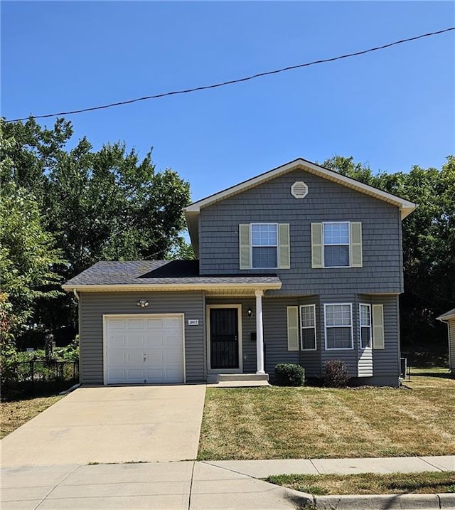 view of property with a garage and a front lawn