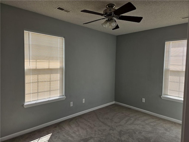 carpeted empty room with baseboards, visible vents, and a textured ceiling