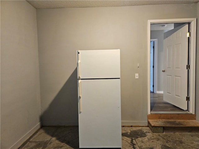 misc room featuring a textured ceiling and baseboards