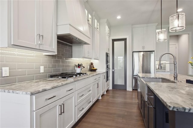 kitchen with custom range hood, light stone countertops, appliances with stainless steel finishes, white cabinetry, and dark hardwood / wood-style floors