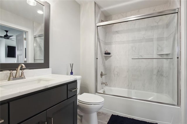 full bathroom with vanity, toilet, combined bath / shower with glass door, and ceiling fan