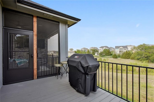 wooden terrace featuring a yard and a grill