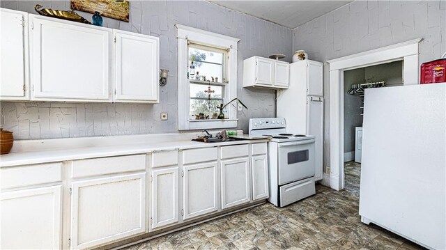 kitchen with sink, white appliances, and white cabinetry