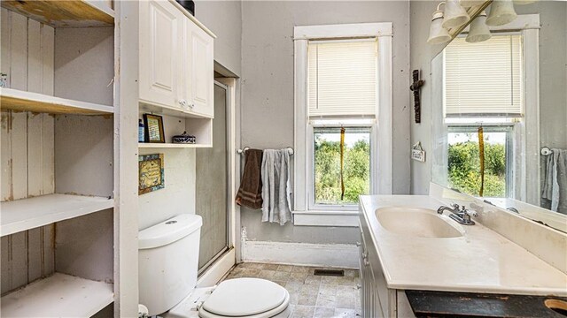 bathroom with a shower with door, vanity, toilet, and wooden walls