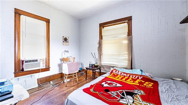 bedroom with wood-type flooring and cooling unit