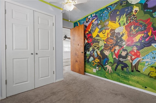 empty room with ceiling fan, carpet, and a textured ceiling