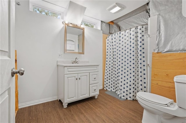 bathroom with plenty of natural light, toilet, vanity, and wood-type flooring