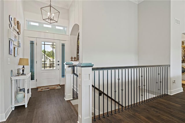 entrance foyer featuring dark wood-type flooring, a high ceiling, and an inviting chandelier