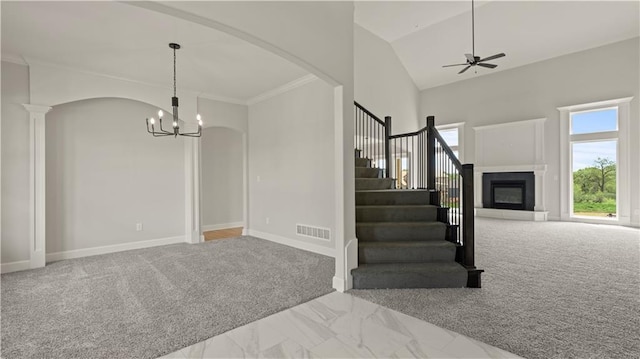 interior space featuring ceiling fan with notable chandelier, ornamental molding, and carpet flooring