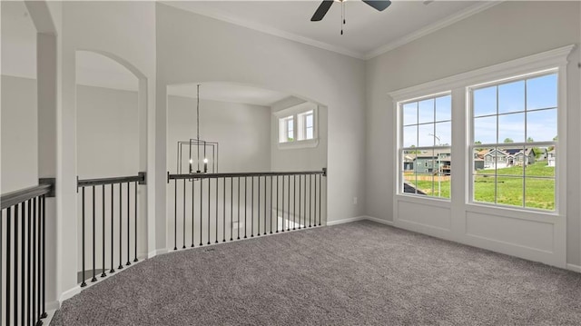 spare room with ceiling fan with notable chandelier, ornamental molding, and carpet