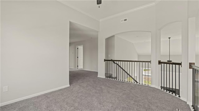 carpeted spare room featuring lofted ceiling, ornamental molding, and ceiling fan