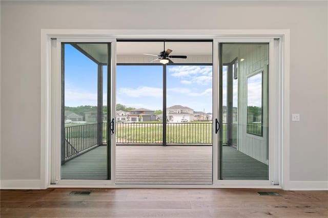 doorway featuring wood finished floors, visible vents, and baseboards