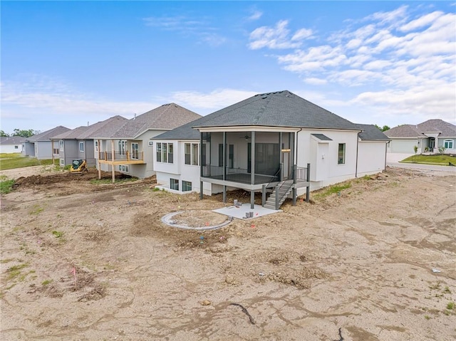 back of property featuring a sunroom, a residential view, and roof with shingles