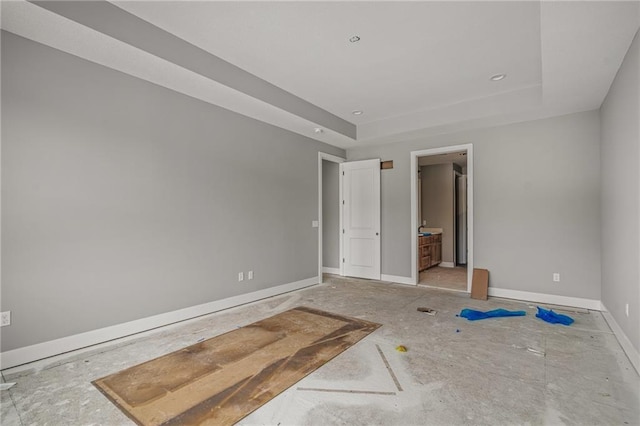 spare room with a raised ceiling and baseboards