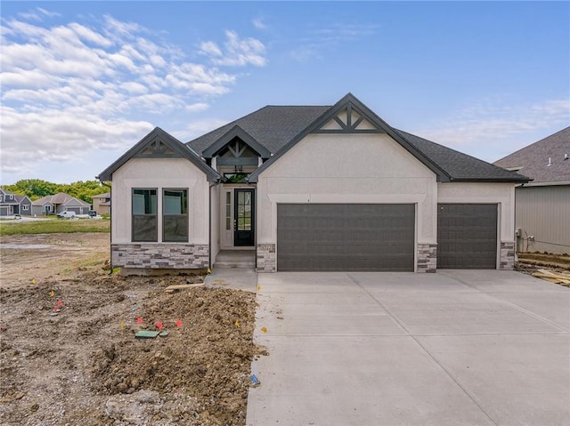 view of front of house with an attached garage, stone siding, concrete driveway, and stucco siding