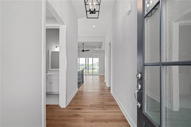 foyer featuring recessed lighting, a notable chandelier, baseboards, and wood finished floors