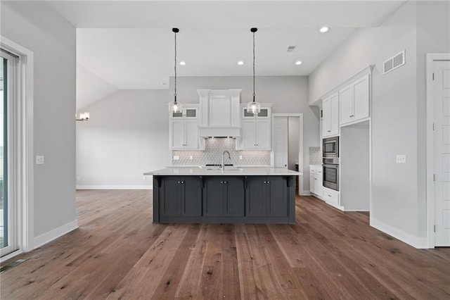 kitchen with visible vents, white cabinetry, light countertops, appliances with stainless steel finishes, and backsplash