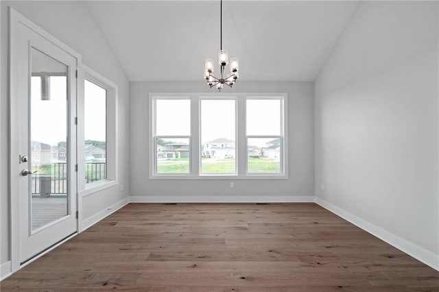 unfurnished dining area featuring lofted ceiling, a healthy amount of sunlight, and a notable chandelier