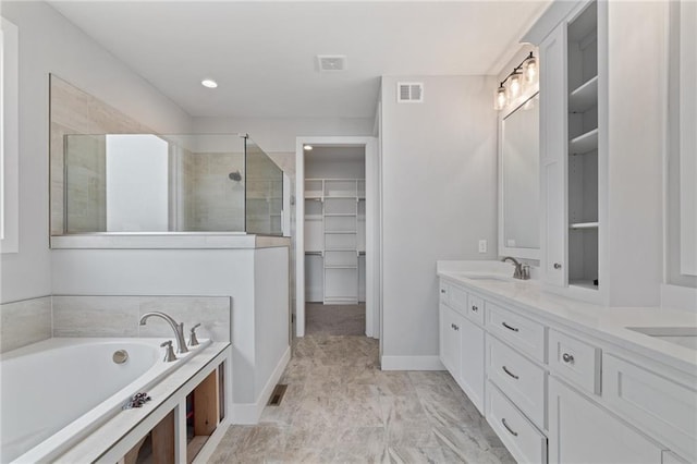 bathroom with double vanity, visible vents, tiled shower, a garden tub, and a spacious closet