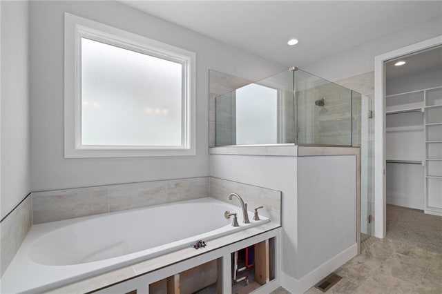 bathroom featuring a walk in closet, recessed lighting, visible vents, a stall shower, and a bath