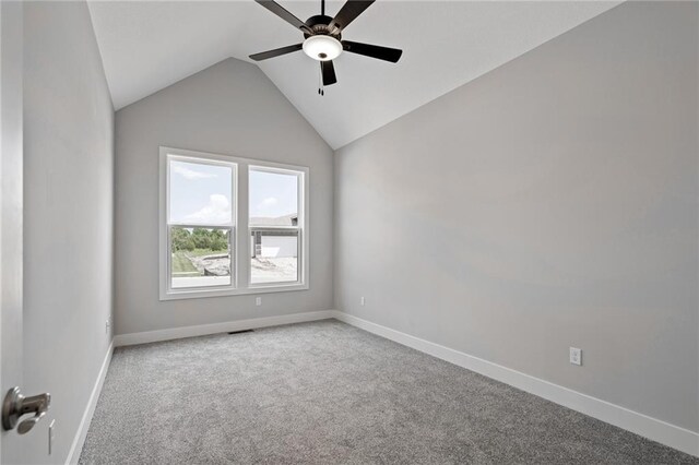 empty room featuring vaulted ceiling, carpet, a ceiling fan, and baseboards