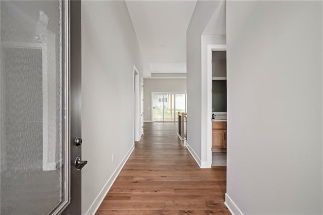 hall featuring baseboards and wood finished floors