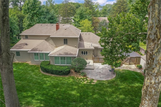 back of house with a lawn and a patio