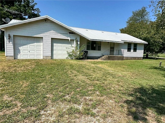 ranch-style house with a front yard, metal roof, driveway, and an attached garage