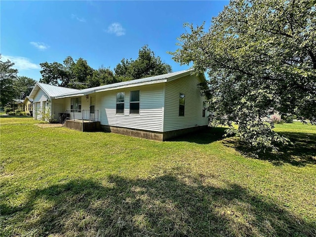 exterior space with metal roof and a front lawn