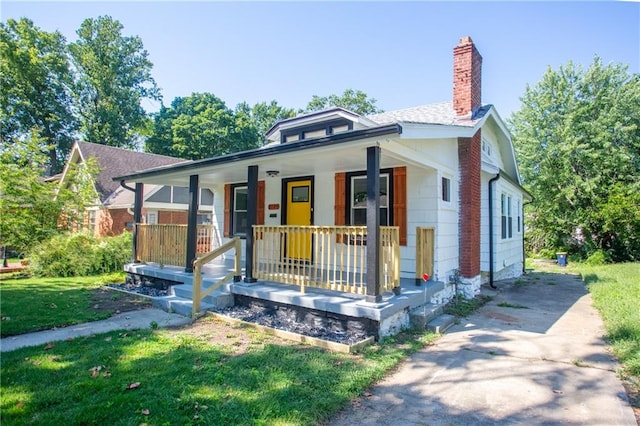 bungalow-style house featuring a porch and a front lawn