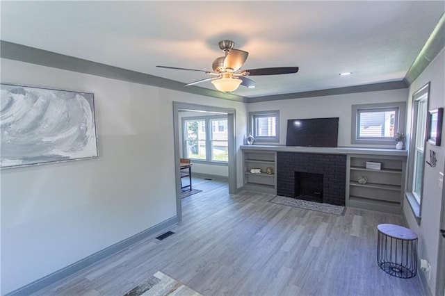 unfurnished living room featuring a fireplace, a wealth of natural light, and hardwood / wood-style floors