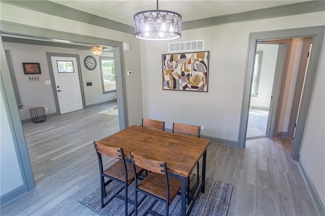 dining room featuring ceiling fan with notable chandelier and hardwood / wood-style flooring