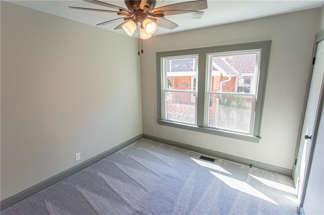 unfurnished room with ceiling fan and carpet