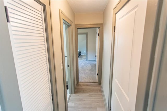 hallway with light hardwood / wood-style floors