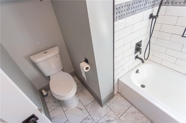 bathroom with toilet and tiled shower / bath combo