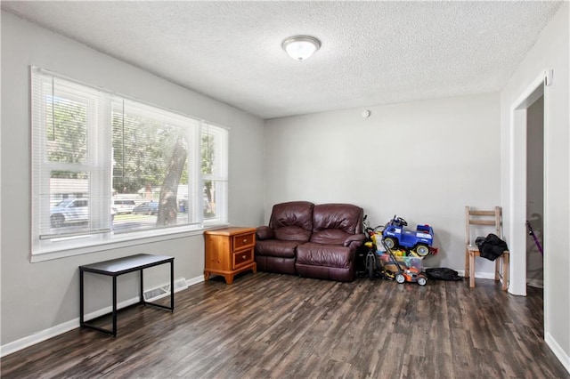 sitting room featuring dark wood-type flooring and a textured ceiling