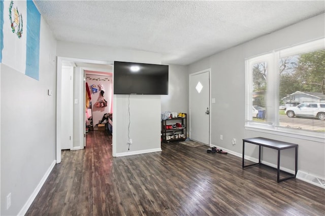 foyer entrance with a textured ceiling and dark hardwood / wood-style flooring