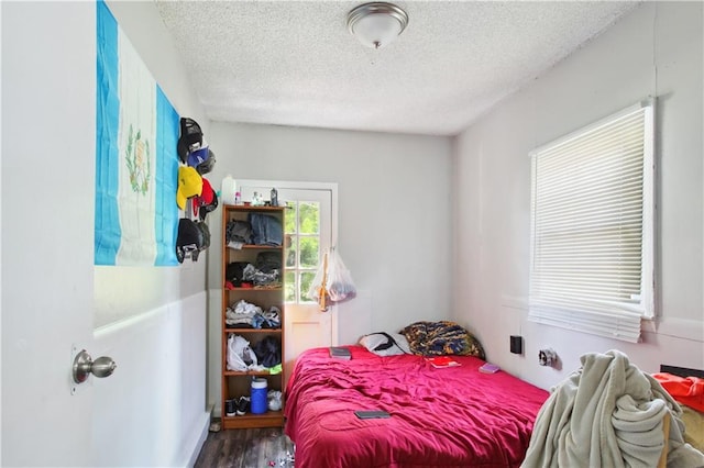 bedroom featuring a textured ceiling and hardwood / wood-style flooring