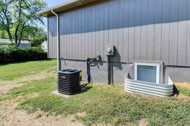 view of side of home featuring a yard and cooling unit