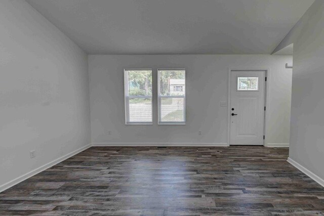 foyer entrance with vaulted ceiling and dark hardwood / wood-style floors